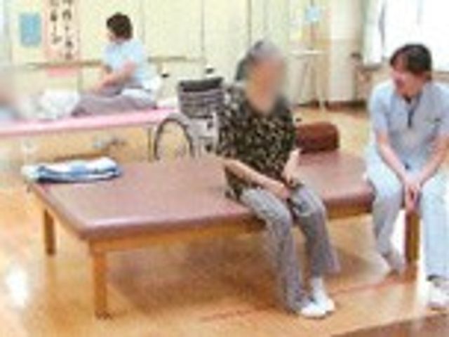 機能訓練の様子 機能訓練室 明るい木目調の室内で、親切なスタッフが利用者とともにトレーニングをサポートしています。