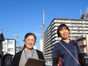 屋外で笑顔の職員2人  