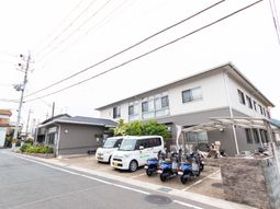 白い壁の建物と駐車場