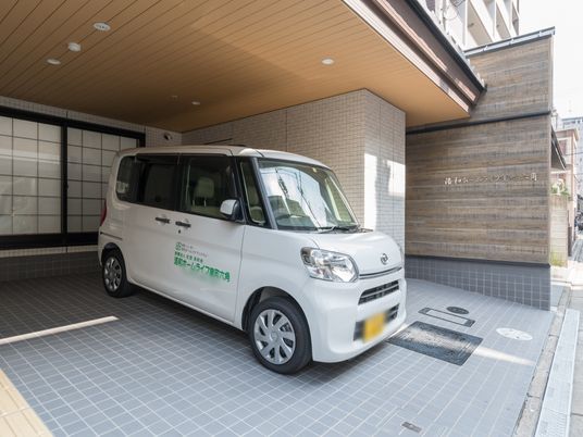白いワゴン車と建物エントランス