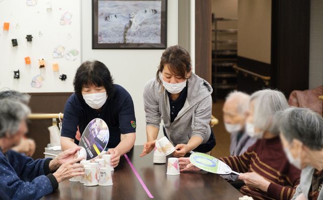 活動するスタッフと利用者 エントランス 利用者と職員が協力して活動を行うシーンです。和やかで明るい雰囲気が魅力的です。
