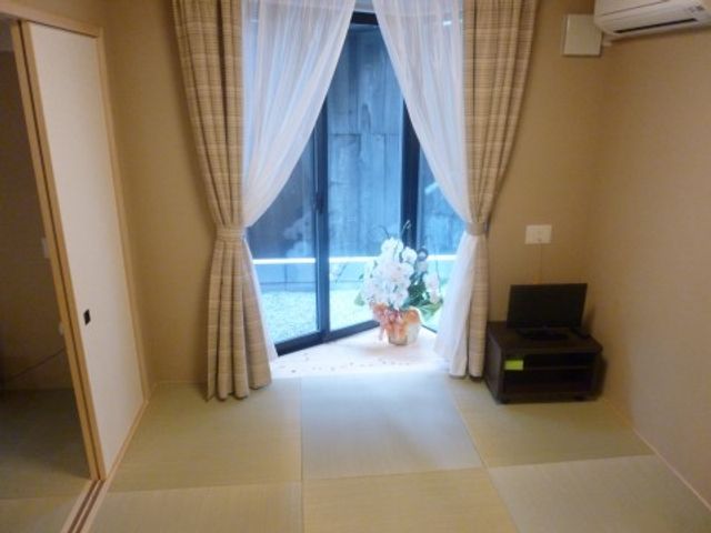 和室と庭の一角 和室 柔らかな光が差し込む落ち着いた和室です。窓越しには小さな庭も垣間見え、ゆったりとした時を過ごせる空間が広がっています。