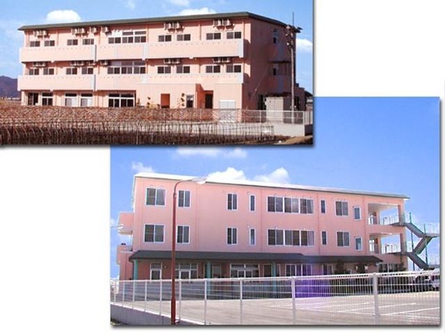 ピンク色の建物外観 外観   淡いピンク色の外壁が印象的な建物です。明るい空の下で、ゆったりとした印象を受けます。