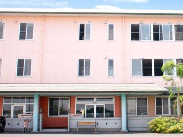 ピンク色の外壁の建物 外観 明るいピンク色の外壁が特徴的な建物です。ゆったりとしたエントランスが迎える、温もりある環境でのお仕事をご検討ください。