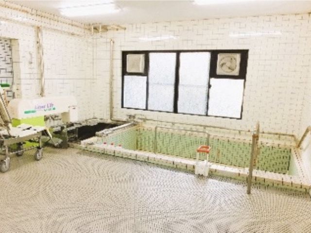 白いタイルの浴室 浴室 明るい空間で、広々とした浴槽が特徴的です。安全に配慮された設備が整っています。