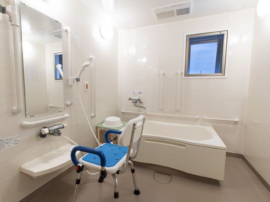 24時間利用可能な浴室には、椅子や手すりが設置されており、使いやすい。壁面には緊急用のボタンも付けられている。