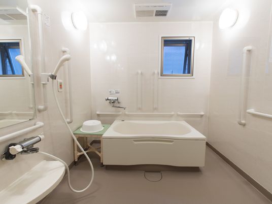 浴室には手すりが多く付けられている。浴槽横の台に洗面器を置いたり腰掛けることもできる。ナースコールがある。
