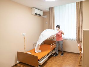 居室でシーツ交換する職員  
