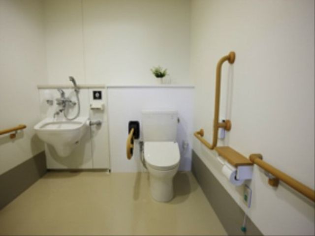 バリアフリーの洗面トイレ トイレ 手すりや緊急コールが完備された清潔感のあふれるトイレで、安心してご利用いただける設備が整っています。