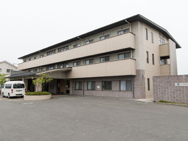 清潔感のある建物外観 施設・外観3 手入れが行き届いた広々とした駐車場と、落ち着いた色調で統一された建物が、働きがいのある環境を提供しています。