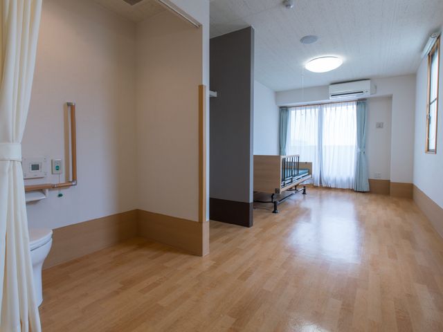 ゆとりある明るい居室空間 居室内1 ゆったりと落ち着いた時間を過ごせる広々とした居室です。窓からは自然光が入り、心地良い空間を提供しています。