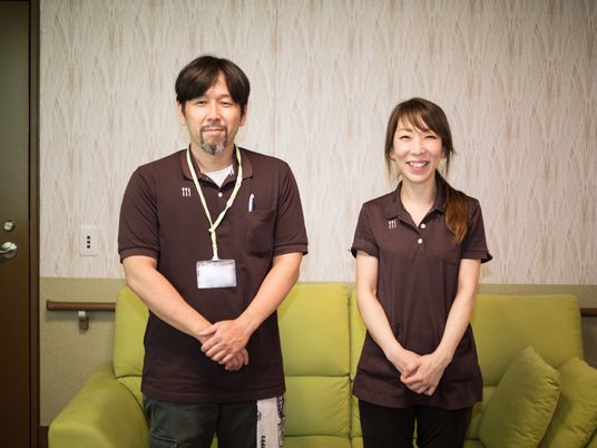 スタッフが笑顔で立つリビング