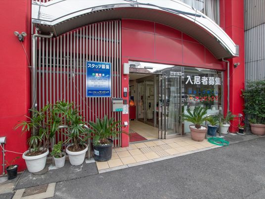 赤色の壁の施設エントランス