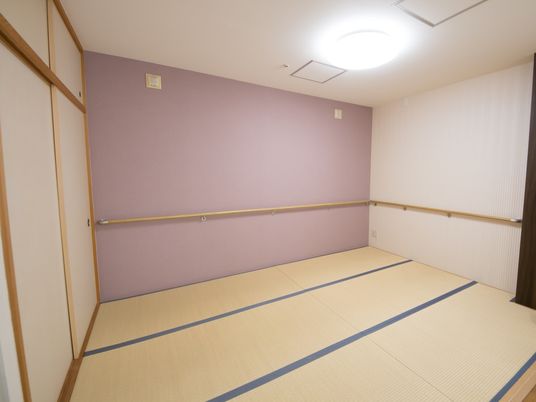 壁片面が気品のある、パープルに施工されている。明るい色合いの畳が敷かれており、広々とした空間である。