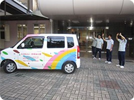 送迎車と職員の外観  