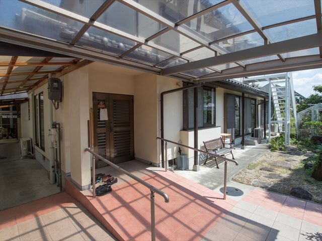 屋根付きエントランス空間 玄関 手すり付きで安心のエントランスでは、静かに読書を楽しむこともでき、訪問者を暖かく迎えます。