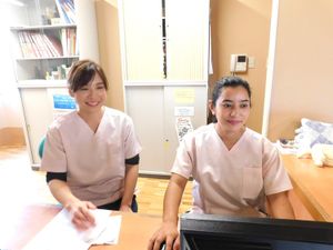 笑顔のスタッフが受付で対応するロビー  