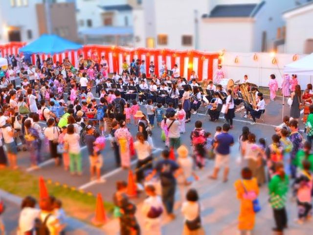 屋外イベント会場 中庭   多くの人が集まり、演奏を囲むにぎやかな屋外スペースです。入居者の交流や季節行事に使えそうな開放感があります。