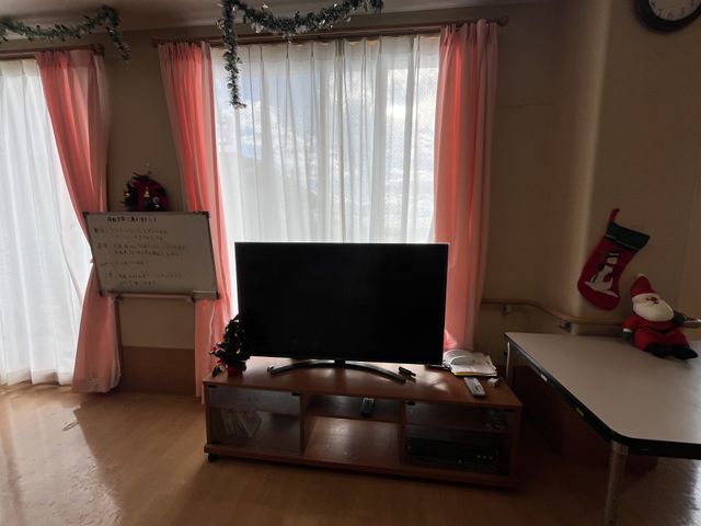 広々としたくつろぎスペース ラウンジ サンタの飾りと明るいカーテンで彩られた空間で、リラックスしながらテレビ鑑賞が楽しめます。