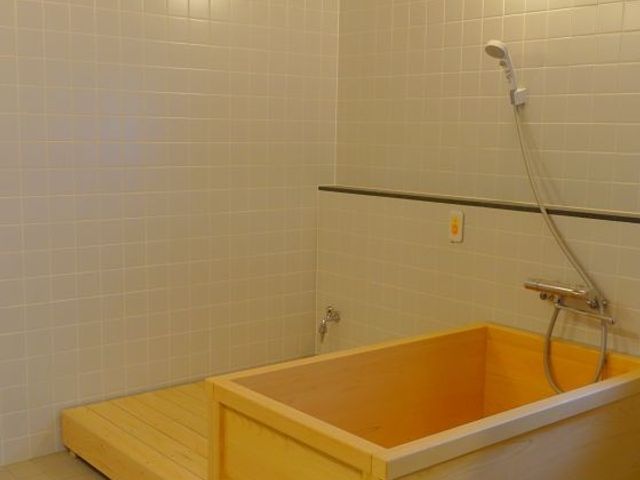 木製浴槽の浴室 浴室   木のぬくもりが感じられる浴槽と、座って使いやすそうな洗い場が見えます。落ち着いた雰囲気で、安心して入浴支援に向き合えそうです。