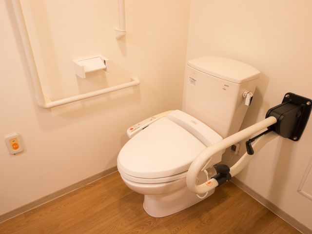 バリアフリートイレ設備 トイレ 手すり付きで安全に配慮された清潔なトイレ空間です。快適な使い心地をサポートする高齢者向けの設備が整っています。