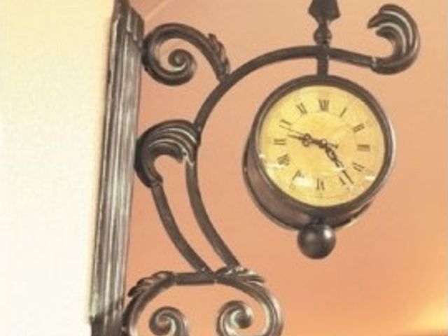 壁掛けの装飾時計 入居者様の生活が第一 ラウンジに設置されたアンティーク調の壁掛け時計です。温かみのある照明のもと、心安らぐ時を刻んでいます。