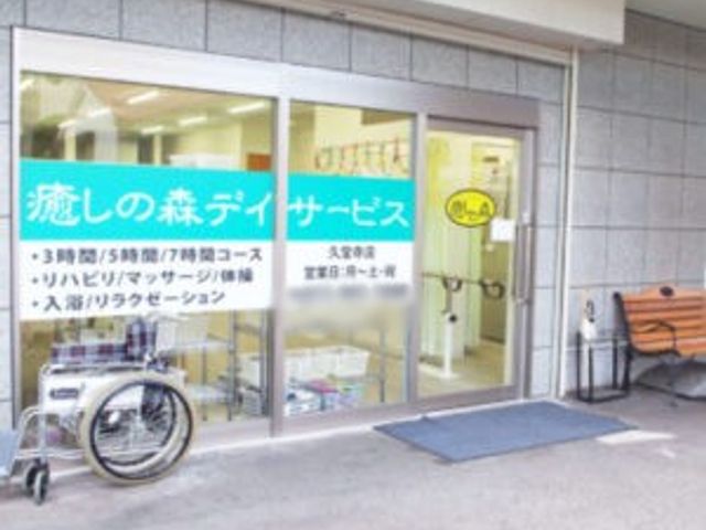 看板が見えるエントランス 看板 入口の看板は、利用者の移動を考慮した作りになっています。自転車や車椅子も置けるスペースがあります。