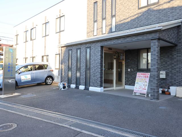 シンプルな建物のエントランス 外観 広々とした入り口は明るい雰囲気を演出し、新たな職場として皆様を歓迎しています。