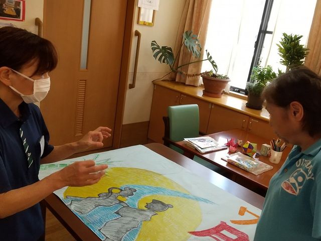 多目的室での作業風景 壁画作成 ゆったりとしたスペースで、利用者とスタッフが共に創造的な活動を楽しむ様子です。明るく開放的な環境で働ける場所です。