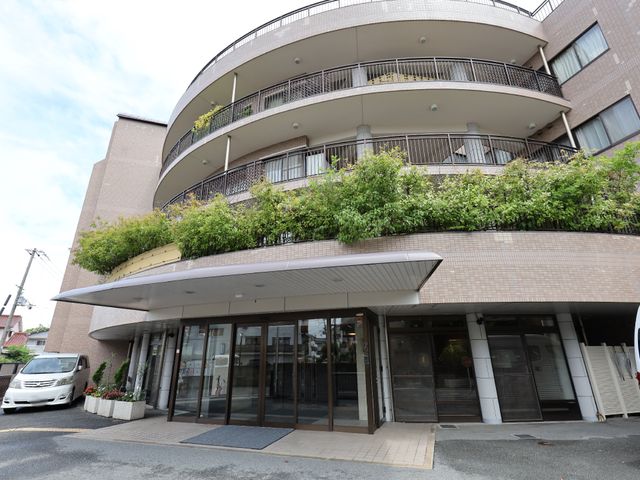 円形バルコニーのある建物正面 外観 植栽に囲まれた温もりのあるエントランスが迎えてくれます。清潔感のあるきれいな外観が印象的です。