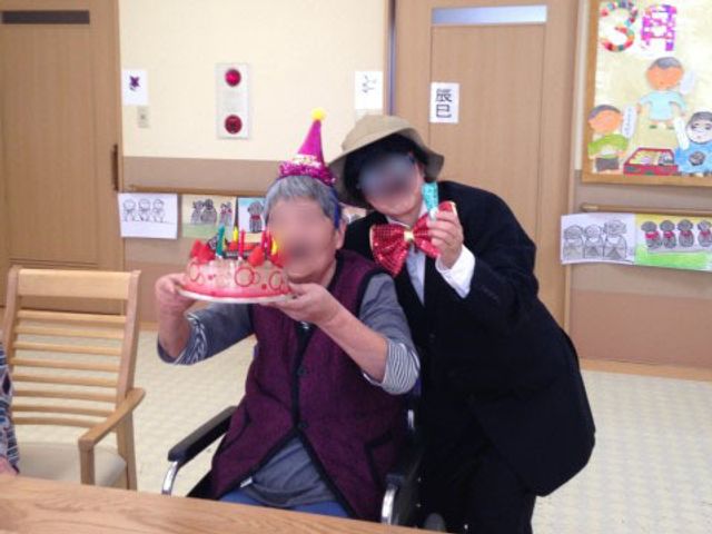 誕生日を祝う美しい瞬間 お誕生日 施設の一コマです。ケアスタッフが利用者様の特別な日をお祝いしている光景が見られます。