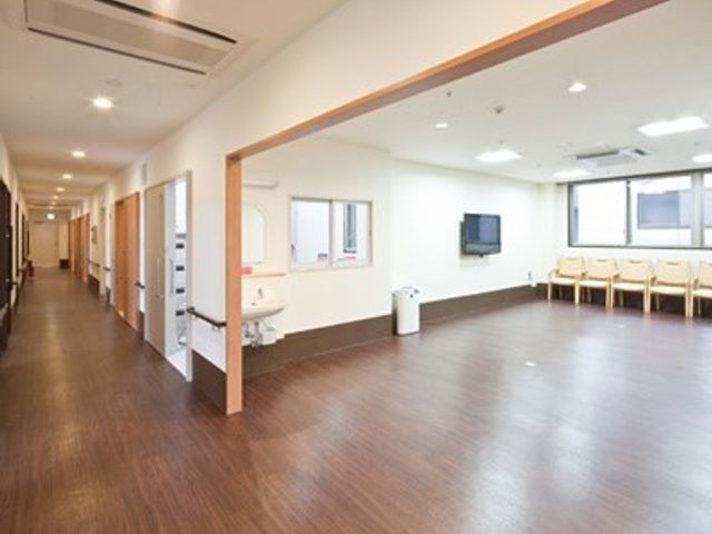 広々とした快適な廊下 共有スペース 木目調の床が温かみを与える、清潔感のあふれる廊下です。待合いスペースには椅子が並び、ゆったりとした時間を過ごせます。