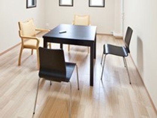 ご家族との面会や、スタッフとの相談などに利用する個室が用意されている。黒と茶のテーブルセットが並べられている。