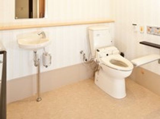 温水洗浄便座を設置したトイレは、壁のパネルで操作するタイプのものになっている。洗面台が備え付けられている。