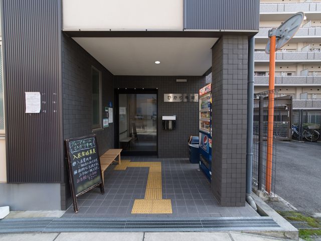 エントランスの外観 玄関 ウェルカムボードが迎える入口は、バリアフリー設計となっており、来訪者を温かく出迎えます。清潔感のある明るい雰囲気が心地よい空間を提供しています。