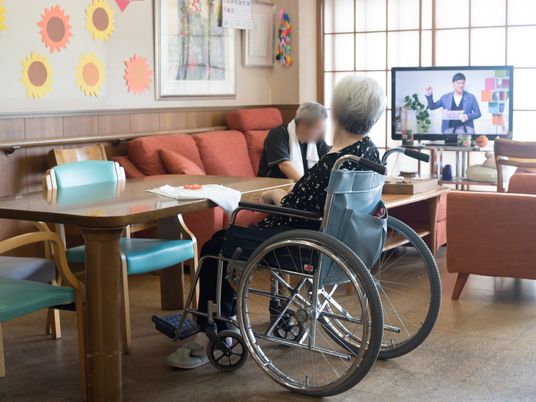 車椅子でくつろぐ人の居室