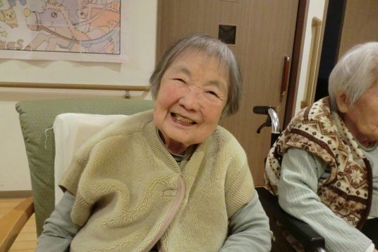 笑顔の高齢者が座る居室