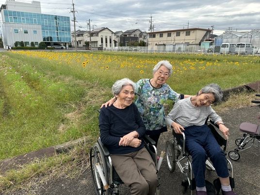 笑顔の高齢者達と花畑