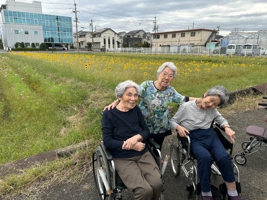 笑顔の高齢者達と花畑