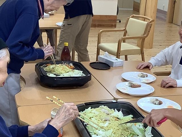 共同調理活動の様子 レクリエーション 複数の方が協力して食事の準備を行っている和やかな食堂です。こうした共同作業は、日々の生活に彩りを添えます。