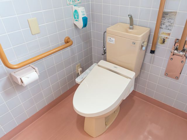 バリアフリートイレ設備 トイレ 安全に配慮した手すり付きの明るいトイレ空間です。利用者の安心と快適さが考えられています。