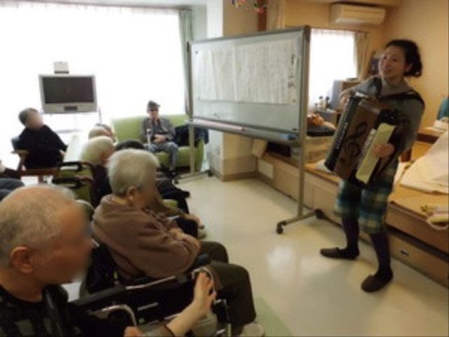楽器演奏のある居室 居間 明るい居室で楽器の演奏が行われており、そこにいる方々は演奏を楽しんでいる様子です。キャリアを積むには充実した環境が整っています。