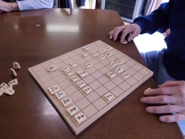 将棋を指す手と盤 娯楽 ゆとりある空間での趣味の時間、コミュニケーションも生まれる居心地の良い場所です。