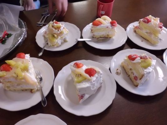 いちご、キウイ、白桃などフルーツがたくさん使用されているケーキが、白い可愛らしいお皿の上に乗っている。