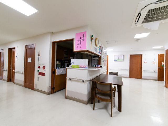 明るい食堂の一角 廊下 広々とした清潔感のあふれる食堂で、入居者様は楽しい食事の時間を過ごされています。カウンター越しの会話も弾む、温かな雰囲気の空間です。