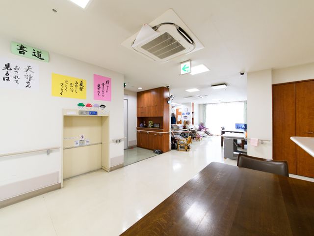 共用スペースの明るい様子 部屋 ゆったりとしたダイニングで利用者様が笑顔で語らう、温かな雰囲気です。ケアの現場で、その笑顔の一部になりませんか。