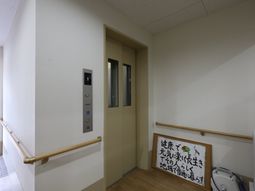 廊下にエレベーターと掲示物