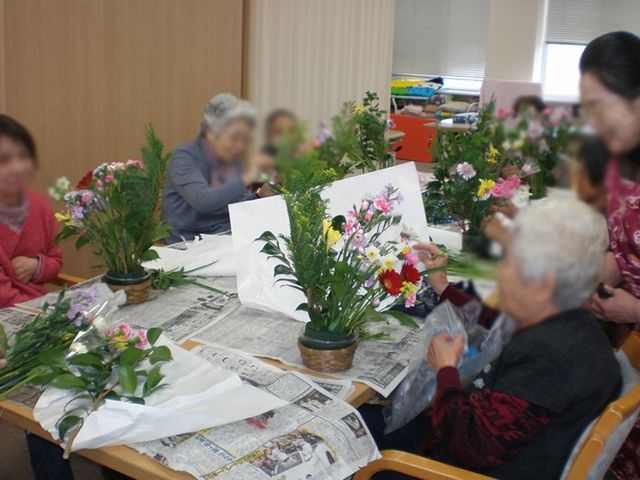 花を生ける高齢者たちの活動 多目的室 植物を生ける皆さんは和やかな雰囲気の中で楽しんでいます。温かみのある空間です。
