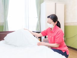 ベッドメイキングするスタッフ