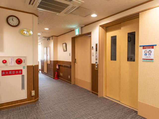 清潔感ある廊下 ゆとりのある通路はすっきりと整えられ、落ち着いた色調で安心感をもたらします。壁には掲示物があり、情報共有も行き届いています。